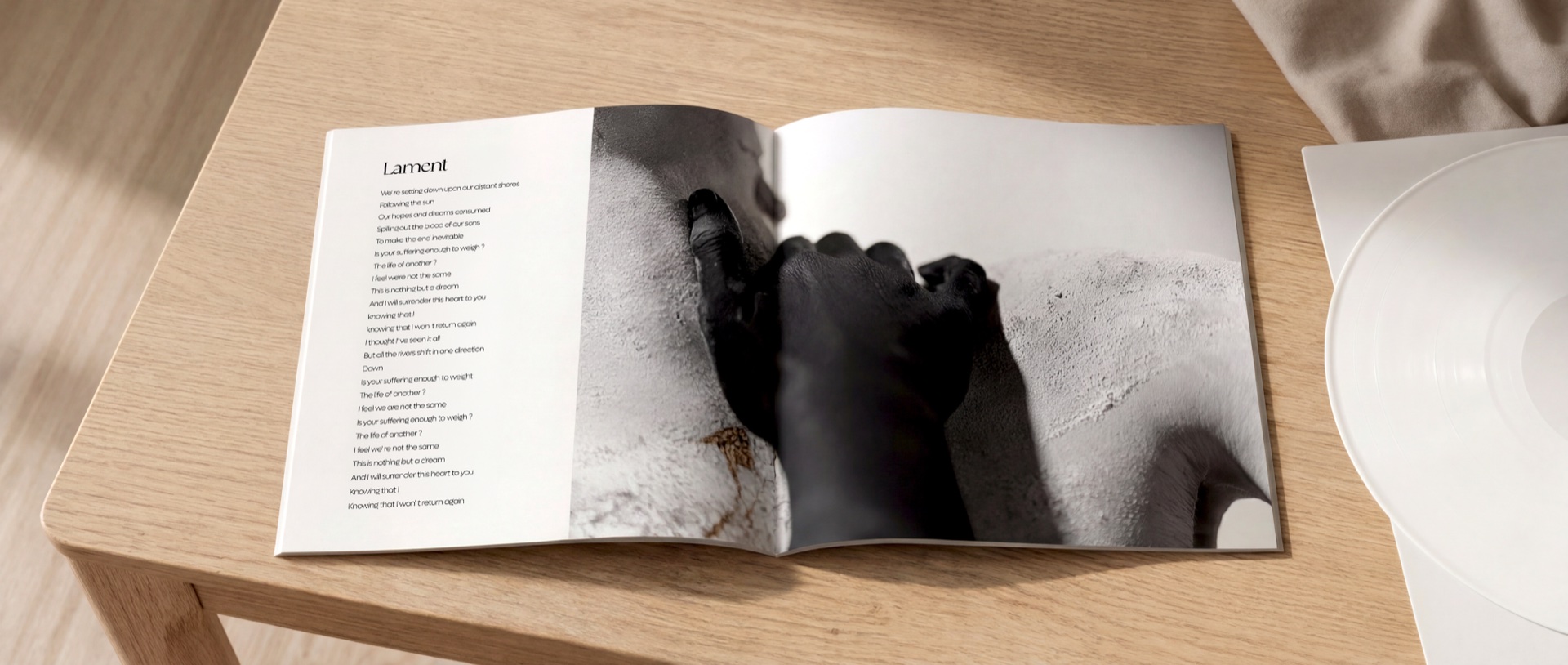 Mask of Prospero album booklet open to the Lament lyric spread on a warm wood table