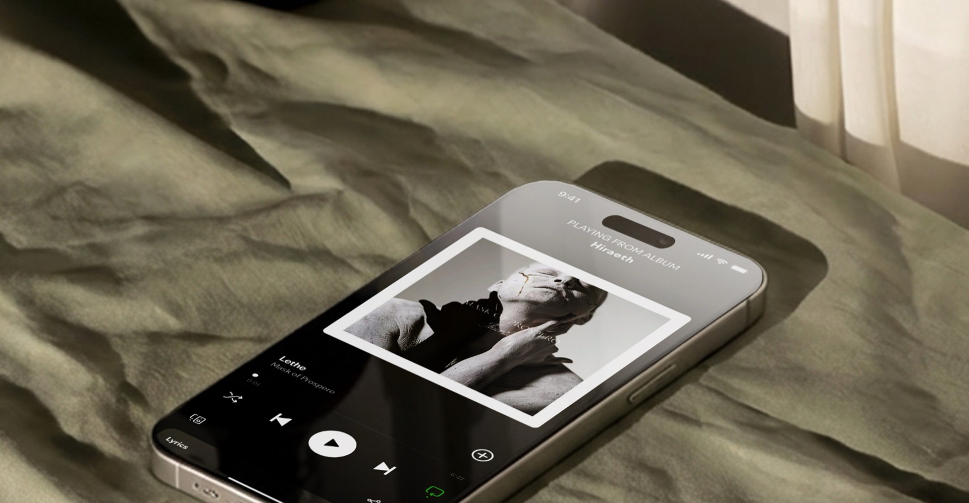 Mask of Prospero album playing on an iPhone music app, the cover artwork visible on screen, resting on a textured fabric