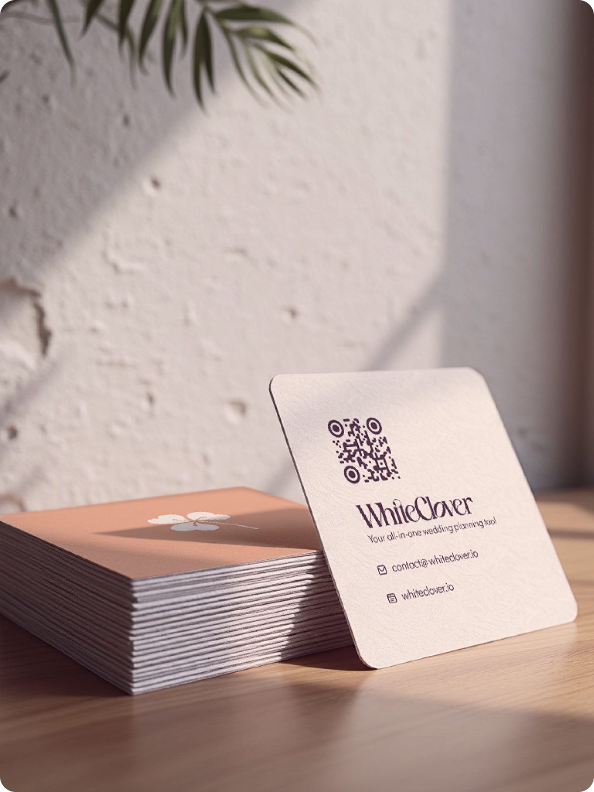 WhiteClover business cards stacked on a textured surface, showing the wordmark and clover icon