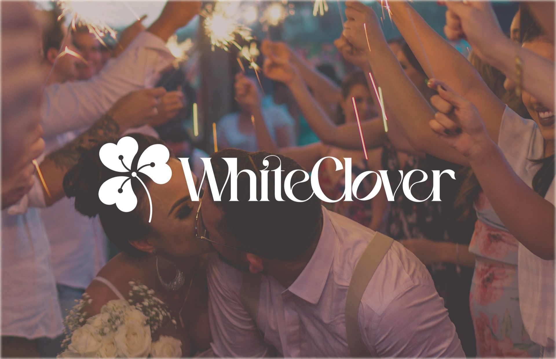 WhiteClover wordmark set over a celebratory wedding photograph, anchoring the brand identity